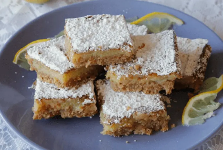 A stack of lemon squares with Cheerios crust garnished with powdered sugar.