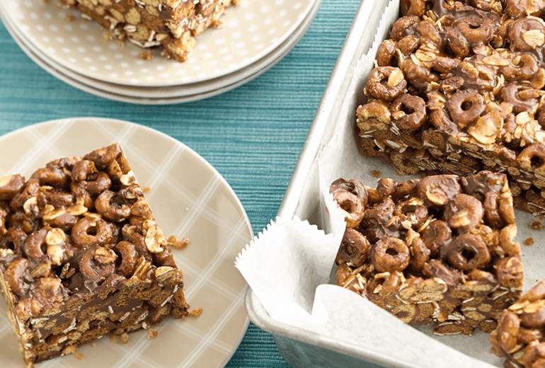 A tray of No-Bake Oatmeal Chocolate Chip Cookie Bars with a couple squares removed and placed onto plates.