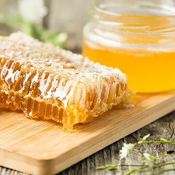 Close-up of a honeycomb and a jar of honey.