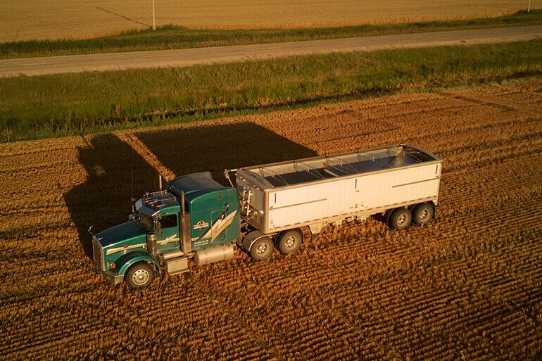 A truck in a farming field at sunset