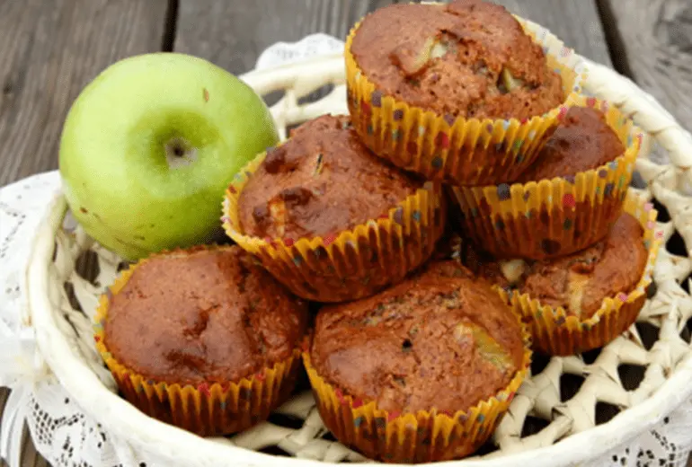 A pile of apple almond muffins made with Apple Cinnamon Cheerios in a basket.