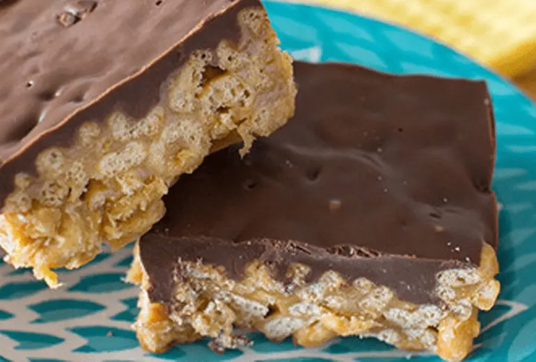 Two peanut butter and chocolate-covered gluten-free Cheerios cereal bars on a blue decorative plate.