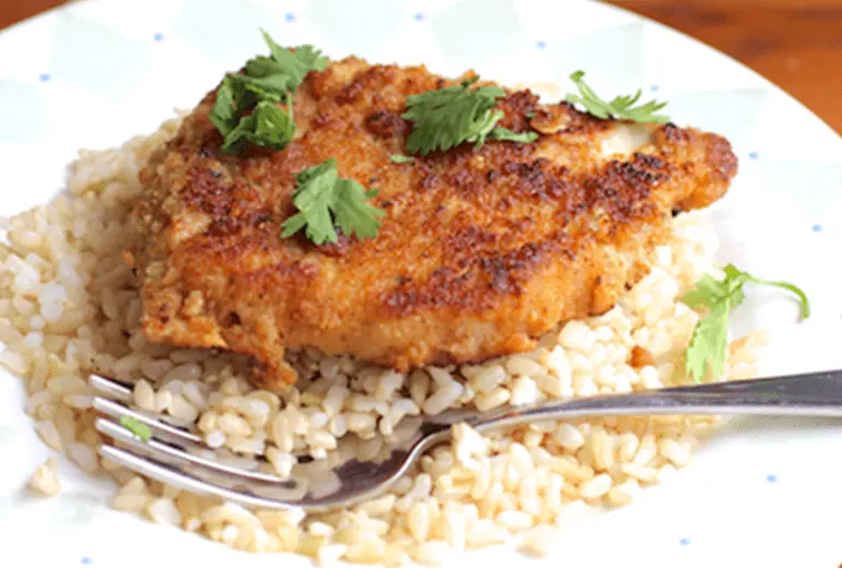 A pork chop breaded with Honey Nut Cheerios on top of rice.