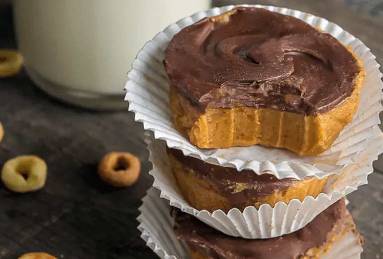 Bites made from Honey Nut Cheerios, peanut butter, and chocolate chips in baking cups stacked on top of each other.
