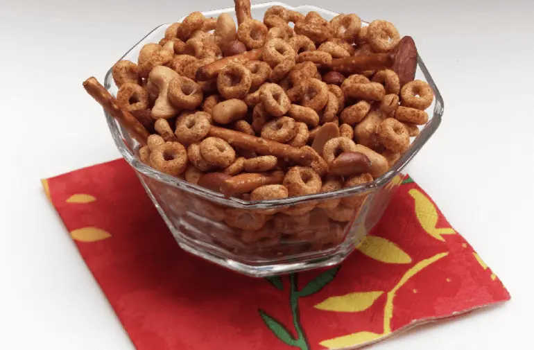 Snack mix in a bowl made with Cheerios, pretzels, and Worcestershire sauce.
